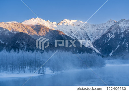 Winter snow hike in Kamikochi: The Hotaka mountain range reflected on the surface of the frosted Taisho Pond 122406680