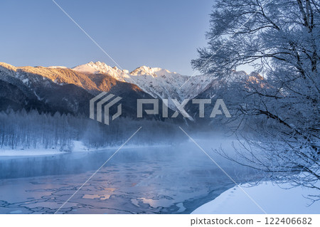 Winter snow hike in Kamikochi: The Hotaka mountain range reflected on the surface of the frosted Taisho Pond 122406682