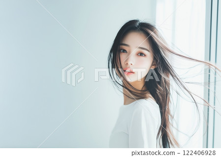 Woman standing by the window with her hair fluttering Woman standing by the window with her hair fluttering 122406928
