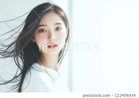 Woman standing by the window with her hair fluttering 122406934