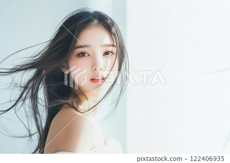 Woman standing by the window with her hair fluttering 122406935