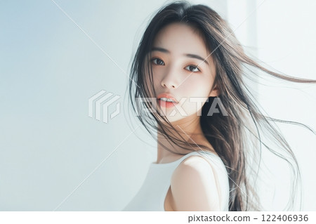 Woman standing by the window with her hair fluttering 122406936