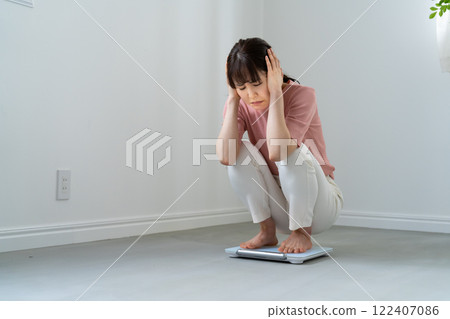 A woman disappointed on riding a scale 122407086
