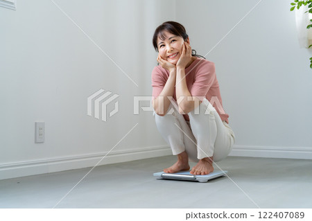 A woman who is happy to weigh herself A woman who is happy to weigh herself 122407089