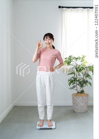 一個女人稱了體重並表示“OK” 122407091