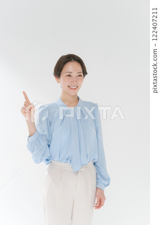 A smiling middle woman pointing A smiling middle woman pointing 122407211