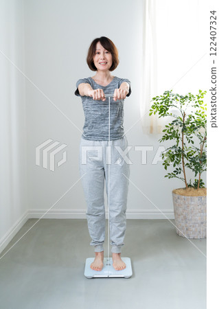 一位女士用身體組成儀測量體重 122407324