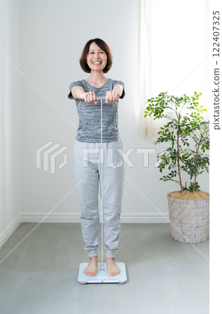 A woman measuring her body weight with a scale 122407325