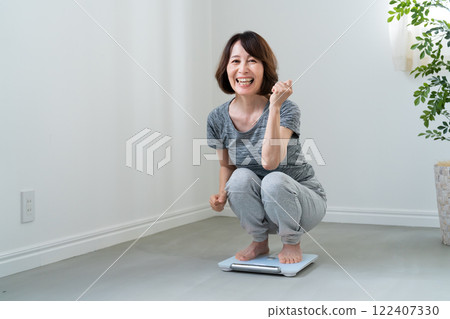 一個在體重計上稱重後很高興的女人 122407330