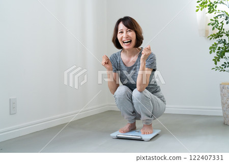 A woman who is happy to weigh herself A woman who is happy to weigh herself 122407331
