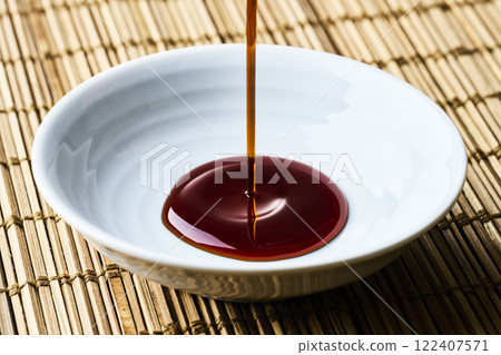 將醬油倒入豆盤中 將醬油倒入豆盤中 122407571
