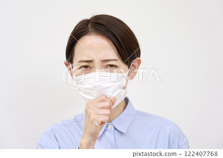 Woman coughing while wearing a cold mask on a white background Woman coughing while wearing a cold mask on a white background 122407768