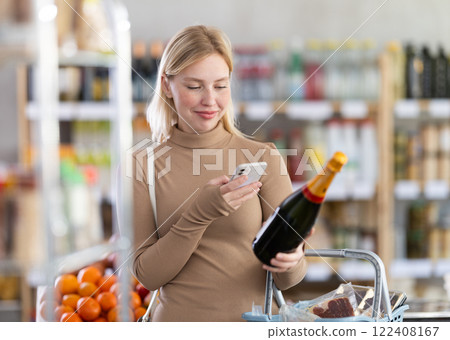 Young woman scanning qr code of champagne 122408167