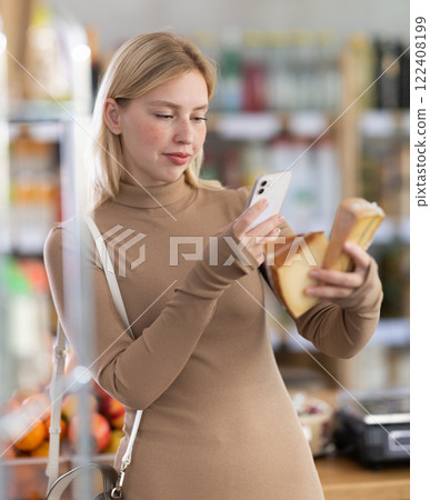 Young woman scanning qr code for cheese 122408199