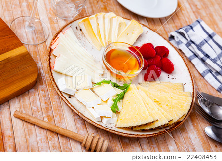 Different types of cheese sliced and served on plate Different types of cheese sliced and served on plate 122408453
