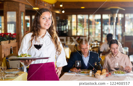 Professional attractive female waiter holding serving tray 122408557