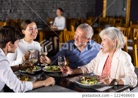 Elderly couple and young couple having dinner in restaurant Elderly couple and young couple having dinner in restaurant 122408603