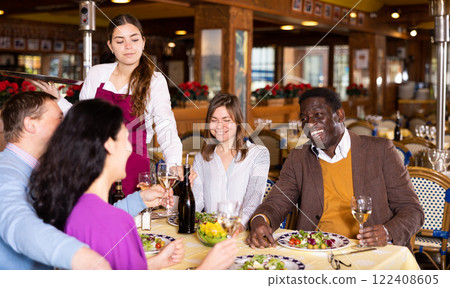 Group of joyous friends enjoying evening meal at restaurant Group of joyous friends enjoying evening meal at restaurant 122408605