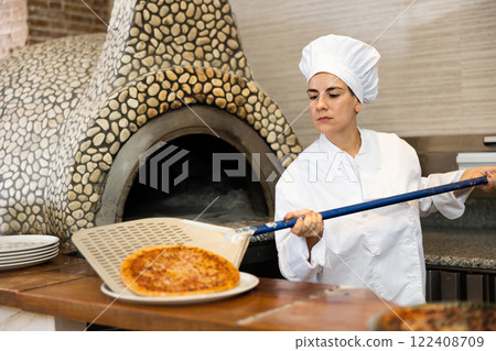 Woman pizza chef at work in restaurant Woman pizza chef at work in restaurant 122408709