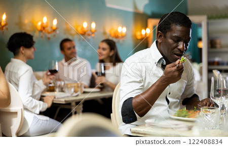 Restaurant visitor enjoying his meal Restaurant visitor enjoying his meal 122408834
