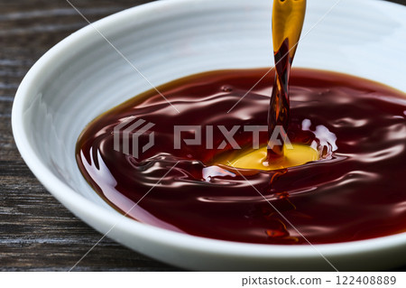 將醬油倒入小盤子中 將醬油倒入小盤子中 122408889