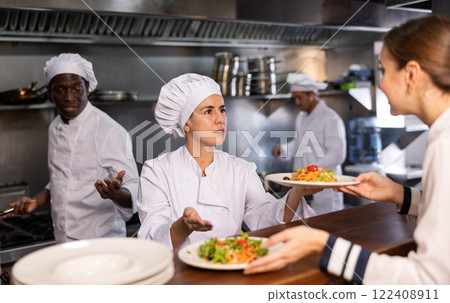 Chef giving out ready salads to waitress 122408911
