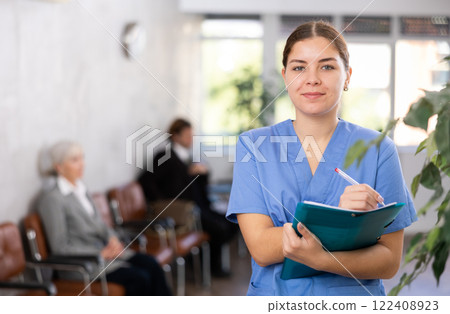 Young woman doctor makes notes in folder 122408923
