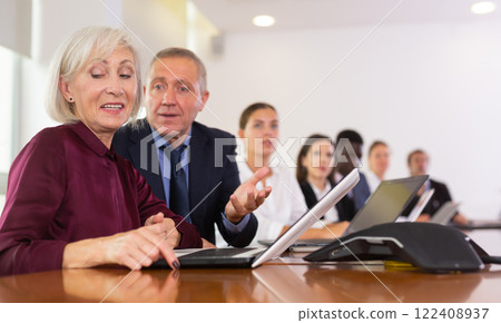 Professional mature male and female colleagues having business discussion during meeting at office Professional mature male and female colleagues having business discussion during meeting at office 122408937