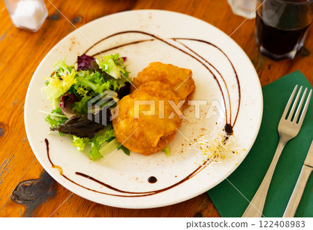 There is plate - stuffed potatoes with meat and garnished with salad of fresh edible green. There is plate - stuffed potatoes with meat and garnished with salad of fresh edible green. 122408983