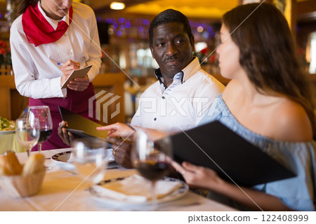 Ordinary female waiter carrying order for visitors in restaurant Ordinary female waiter carrying order for visitors in restaurant 122408999