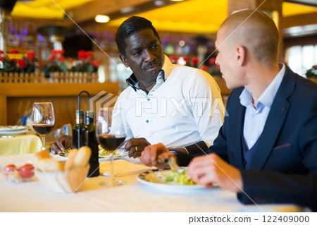 Two men discussing problems at table in restaurant Two men discussing problems at table in restaurant 122409000