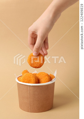 Fried mozzarella in a cardboard box on a beige background Fried mozzarella in a cardboard box on a beige background 122409819