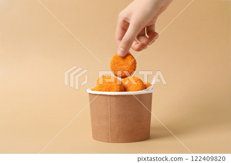 Fried mozzarella in a cardboard box on a beige background 122409820