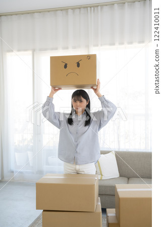 一位女士拿著一個紙板箱，上面有臉部插圖 122410011