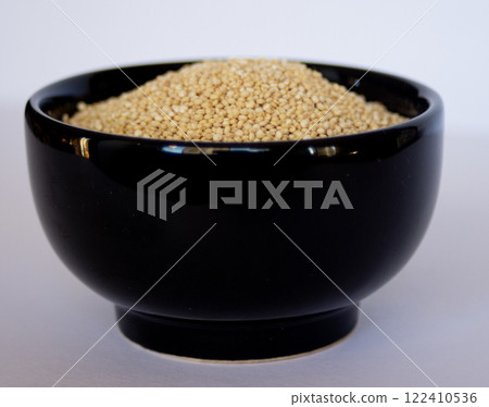 Quinoa grains in black bowl. side view picture in white background. Quinoa grains in black bowl. side view picture in white background. 122410536