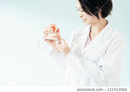 Dentist woman holding a tooth model Dentist woman holding a tooth model 122412068