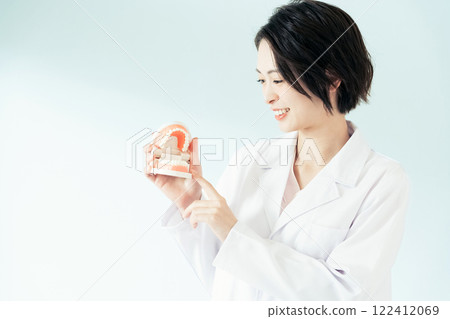 Dentist woman holding a tooth model Dentist woman holding a tooth model 122412069