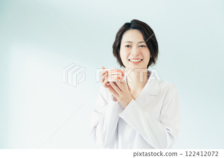 Dentist woman holding a tooth model 122412072