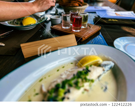 Fried Golden trout fish with lemon and herbs in a white plate on a wooden table at the restaurant in Ukraine Fried Golden trout fish with lemon and herbs in a white plate on a wooden table at the restaurant in Ukraine 122412226