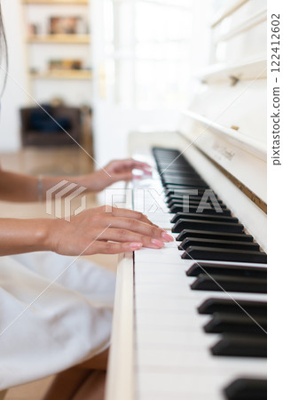 Close-up of a female hands on the piano keys side view vertical shot 122412602