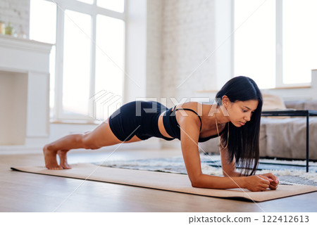 Woman in plank position exercising home workout healthy sport fitness lifestyle at home plank exercise working out Woman in plank position exercising home workout healthy sport fitness lifestyle at home plank exercise working out 122412613