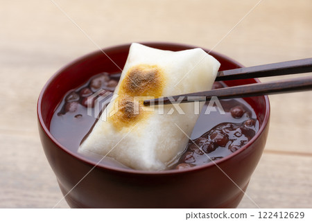 Eating fragrantly roasted zenzai with mochi using chopsticks Eating fragrantly roasted zenzai with mochi using chopsticks 122412629