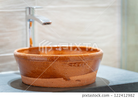 Rustic Clay Sink in Modern Bathroom Setting 122412982