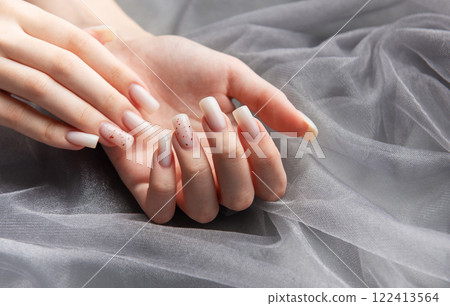 Woman showing stylish trendy female manicure on gray background Woman showing stylish trendy female manicure on gray background 122413564