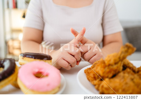 A woman refuses to eat fast food, fried chicken and donuts on her plate to lose weight and stay healthy A woman refuses to eat fast food, fried chicken and donuts on her plate to lose weight and stay healthy 122413807