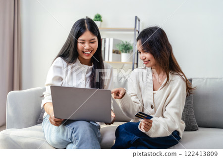 Two women are using laptops and credit cards to pay for purchases and shopping online Two women are using laptops and credit cards to pay for purchases and shopping online 122413809