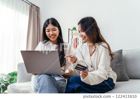 Two women are using laptops and credit cards to pay for purchases and shopping online Two women are using laptops and credit cards to pay for purchases and shopping online 122413810
