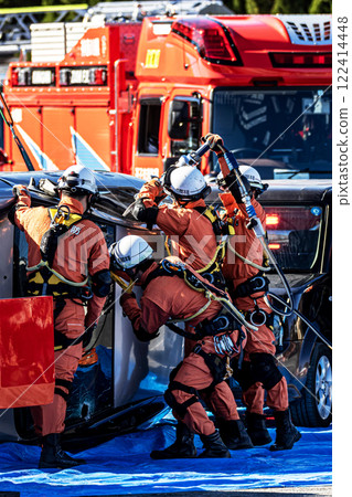 Rescue team members perform rescue training using a hydraulic cutter to cut off the roof of a car that has overturned in an accident during a fire drill at the New Year's ceremony. 122414448