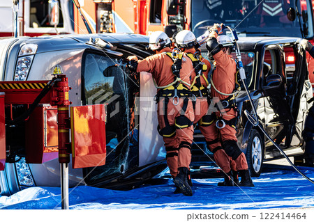 Rescue team members perform rescue training using a hydraulic cutter to cut off the roof of a car that has overturned in an accident during a fire drill at the New Year's ceremony. 122414464