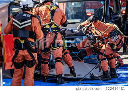 Rescue team members perform rescue training using a hydraulic cutter to cut off the roof of a car that has overturned in an accident during a fire drill at the New Year's ceremony. 122414481